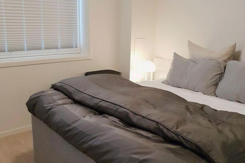 特罗姆瑟Book an apartment just for you in central Tromsø的卧室里的一张带毯子的床