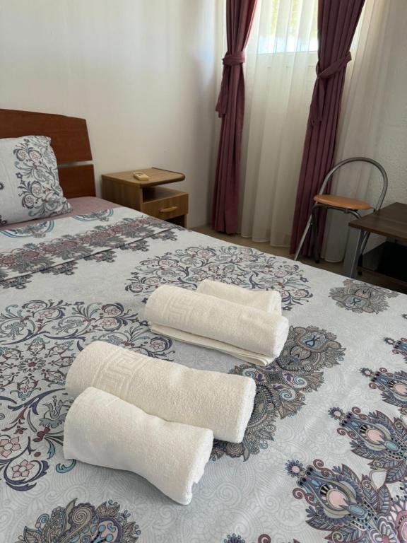 波德戈里察Apartments Airport Golubovci 2的床上有两条白色毛巾