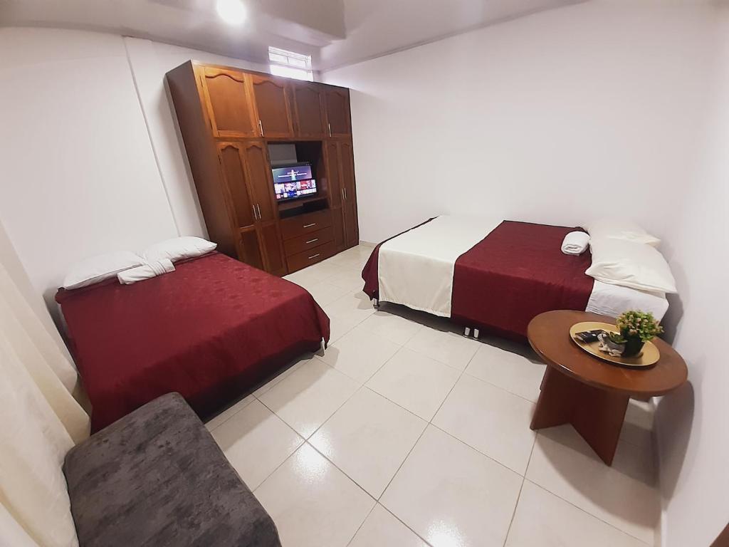 波帕扬Apartamento en centro de Popayán的酒店客房,设有两张床和一张桌子及椅子