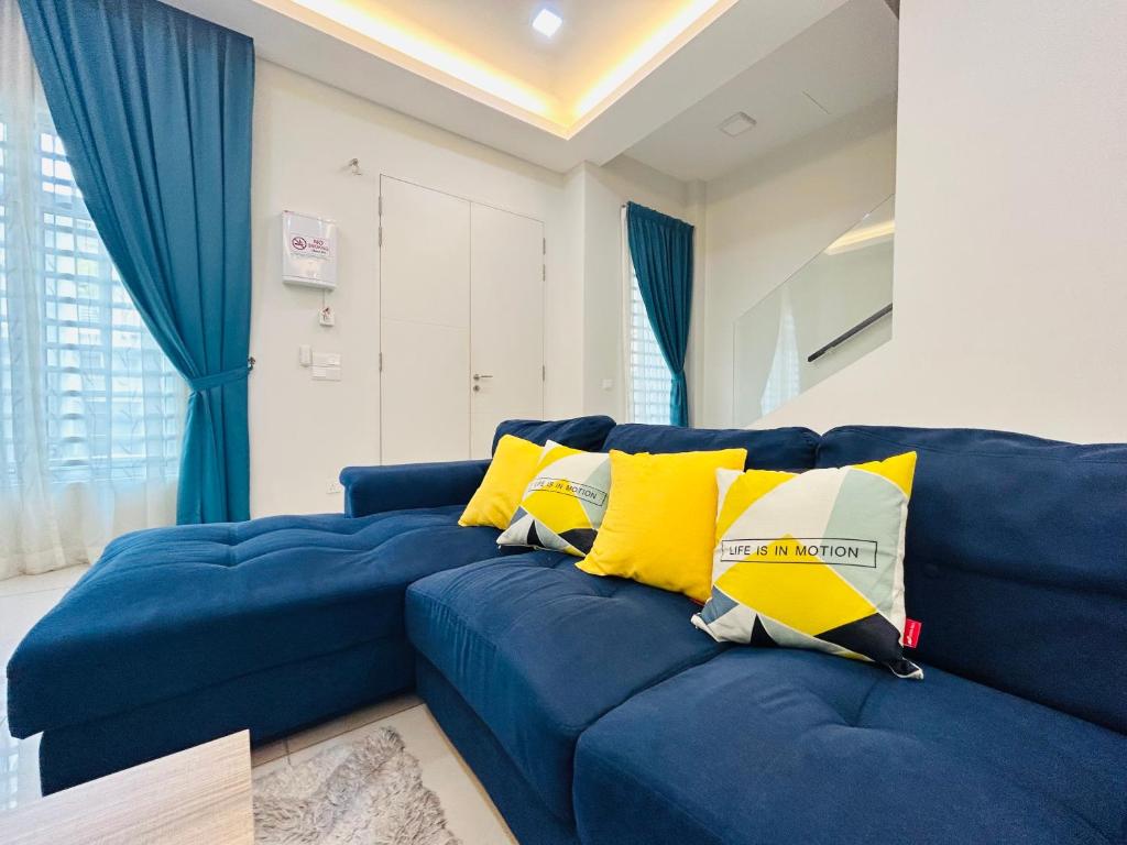 马六甲Insyirah Homestay Melaka的客厅里配有带黄色枕头的蓝色沙发