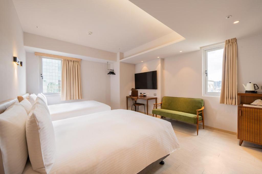 高雄瘾室 Inns Hotel的卧室配有白色的床和绿色椅子