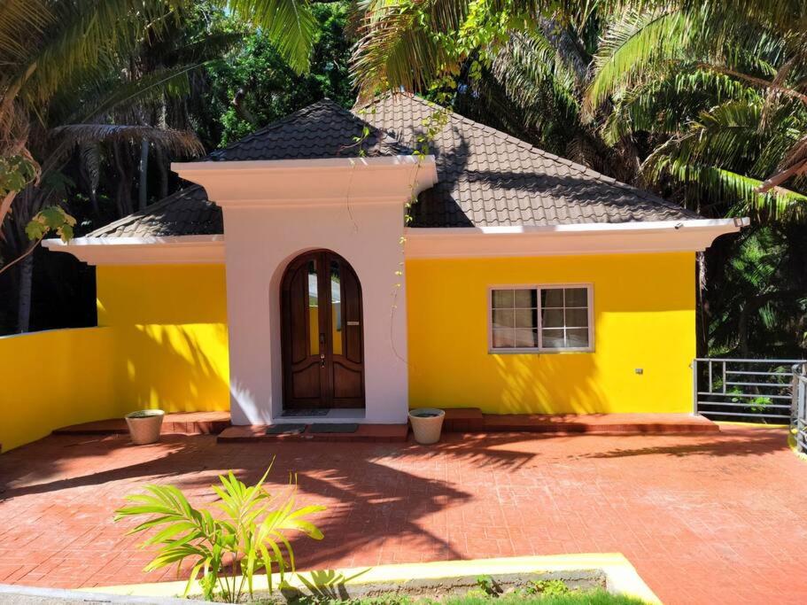 罗阿坦Spacious & Spotless new house, 4 BRs的黄色的房子,前面有一扇门
