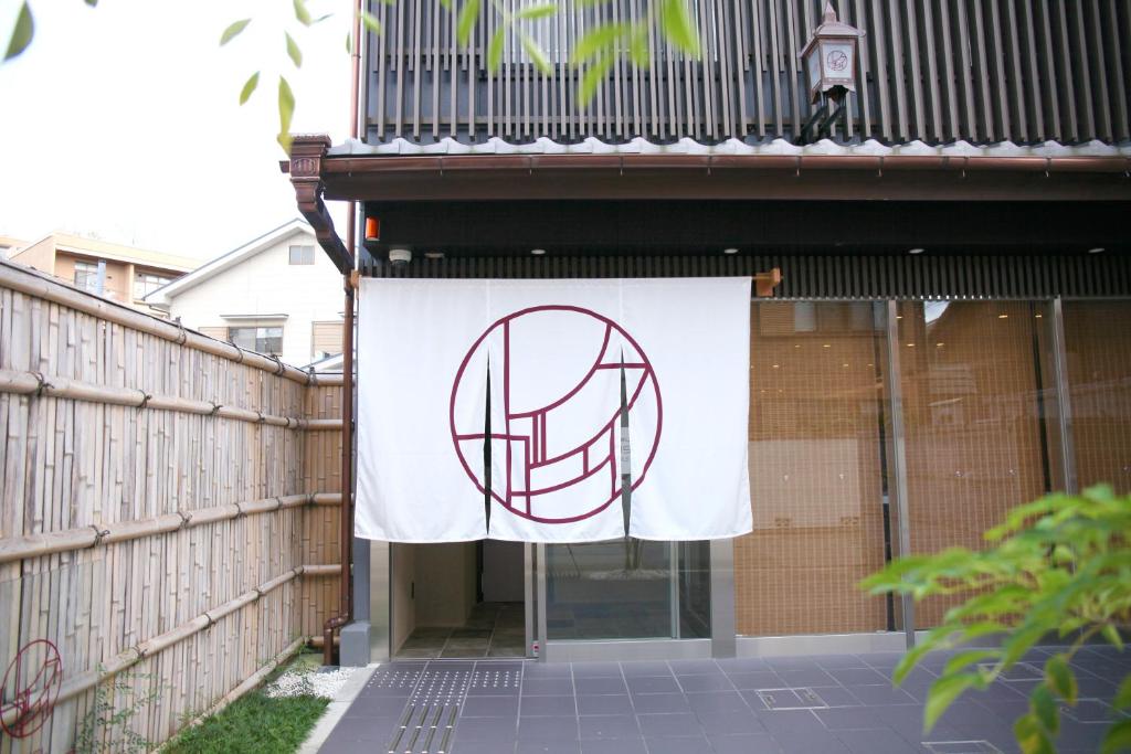 京都HOTEL LEGASTA KYOTO SHIRAKAWA SANJO的悬挂在建筑物一边的旗帜