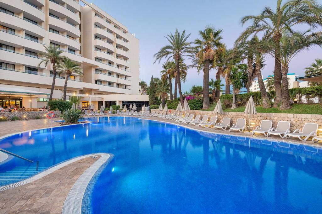 萨科马Welikehotel Marfil Playa的一个带椅子的大型游泳池和一间酒店