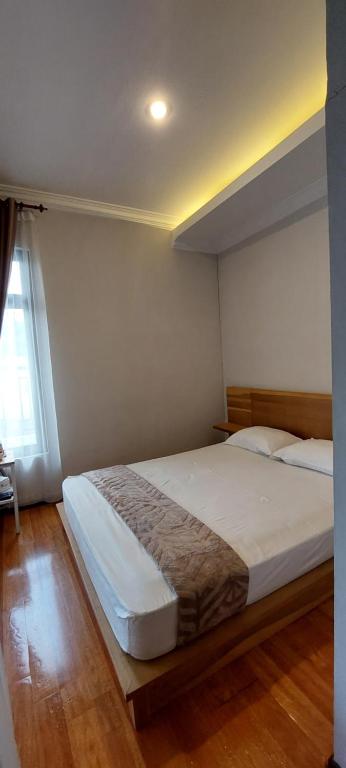 武吉丁宜Syakirah Guest House Syariah的一间卧室设有一张大床和一个窗户。