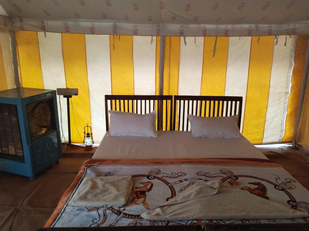 KhuriJaisalmer Safari Base & Camp的一间卧室配有一张床和一个壁炉