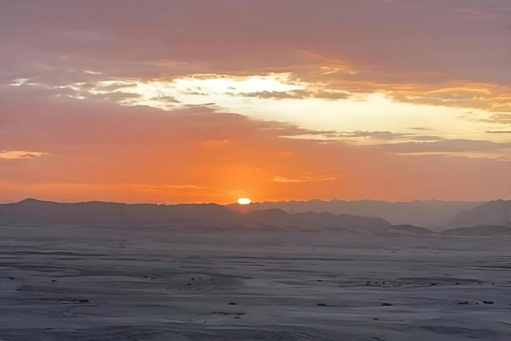 斯瓦科普蒙德Moon Landscape Self Catering的沙漠上的日落,背景是群山