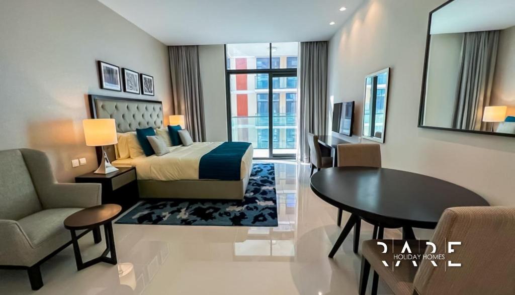 迪拜Rare Holiday Homes - Spacious apartment - Near Expo City - Dubai South - R410的卧室配有1张床、1张桌子和1把椅子