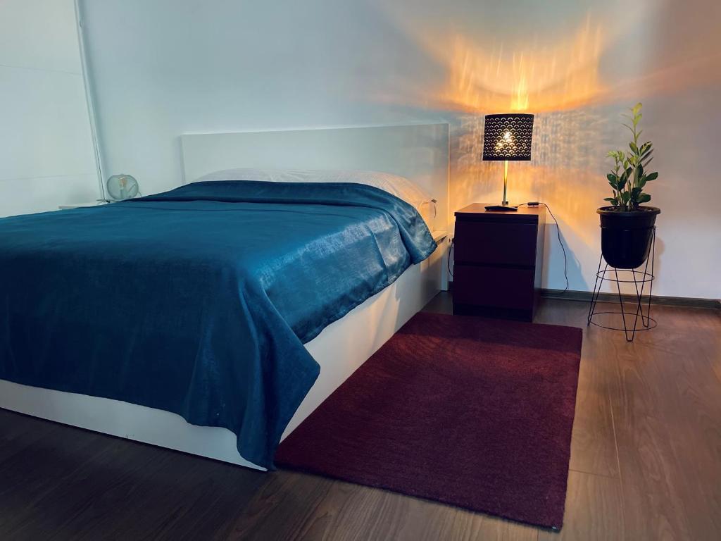 布加勒斯特City Garden Apartments的一间卧室配有床、灯和地毯