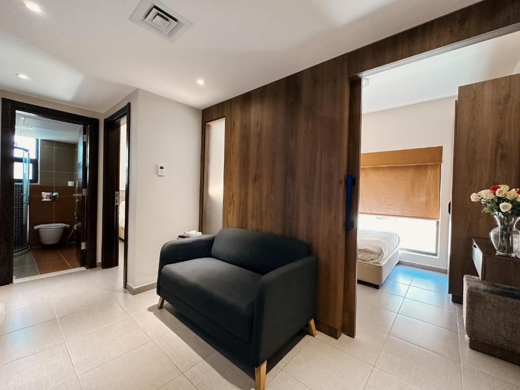 安曼切利诺公寓式酒店的一间带椅子的客厅和一间卧室