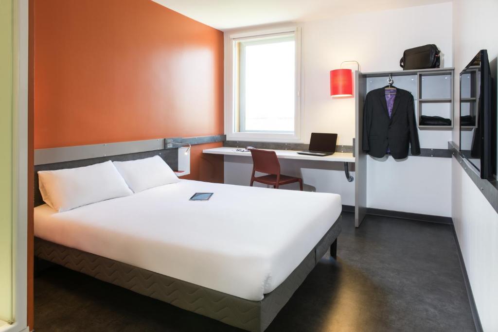 圣艾修伯里里昂圣艾修伯里机场宜必思快捷酒店的一间卧室配有一张床和一张带电脑的书桌