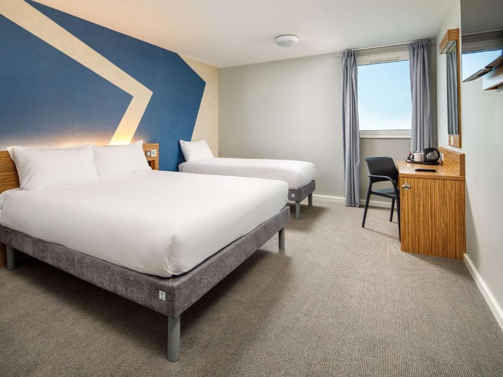 豪士罗ibis budget London Heathrow Central的酒店客房配有两张床和一张书桌