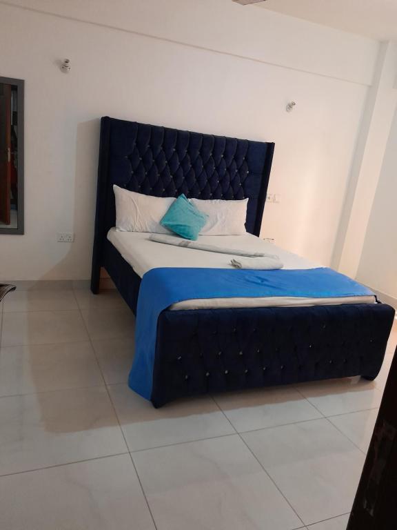 蒙巴萨MEDZAM HOME PROPERTIES COSY One bedroom的一张大床,在房间里设有黑色床头板