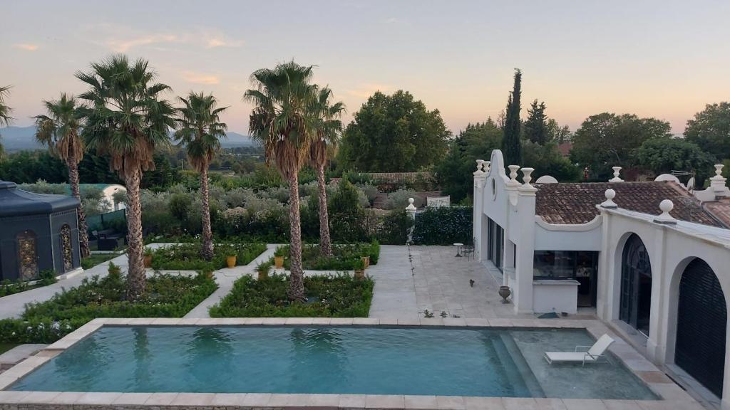 普罗旺斯艾克斯Maison Blue Palm Aix en Provence的享有带游泳池和棕榈树的别墅的空中景致