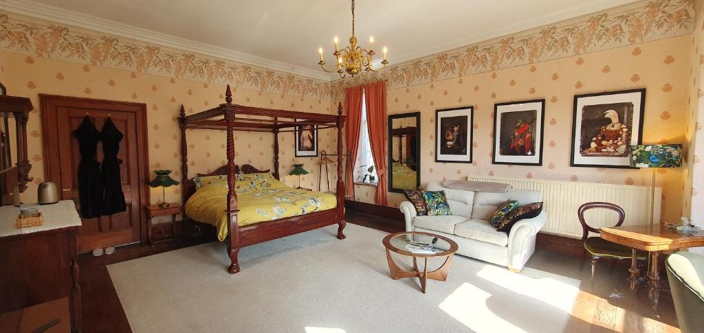 多尔盖罗Cader Suite at PenYcoed Hall incl Luxury Hot Tub的一间卧室配有一张床、一张沙发和一把椅子