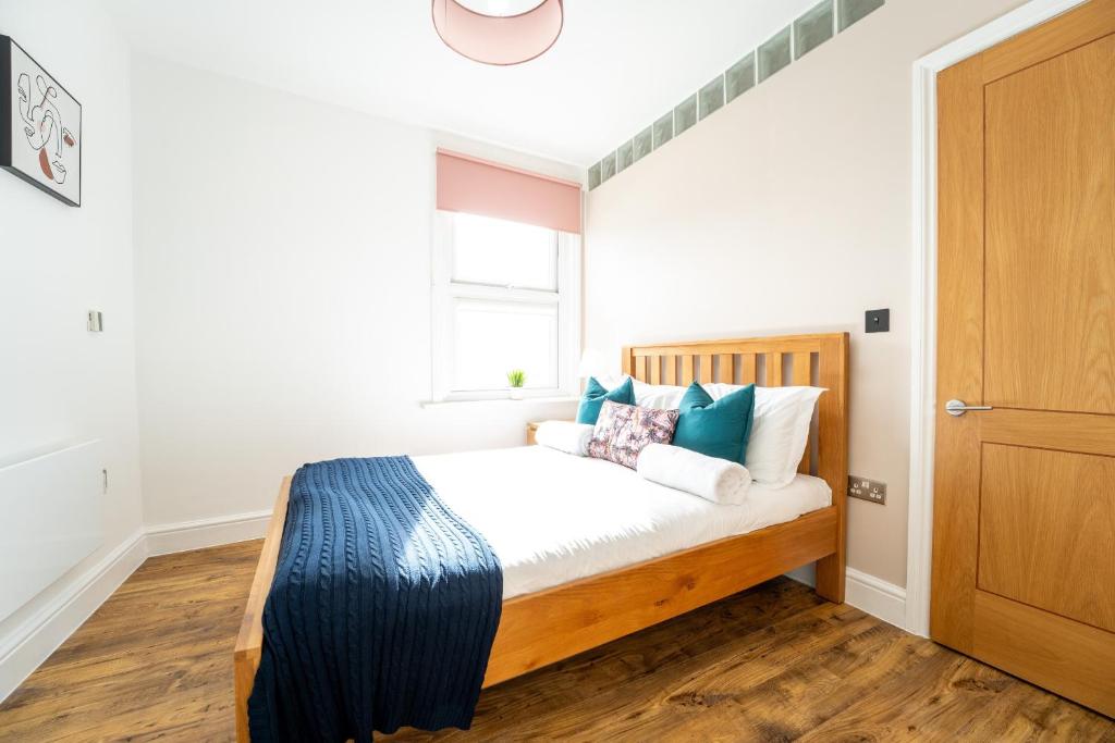 红山Redhill Garland- 1 bed ground floor apartment by LGW Short Lets的一间卧室配有一张带蓝色和白色枕头的床