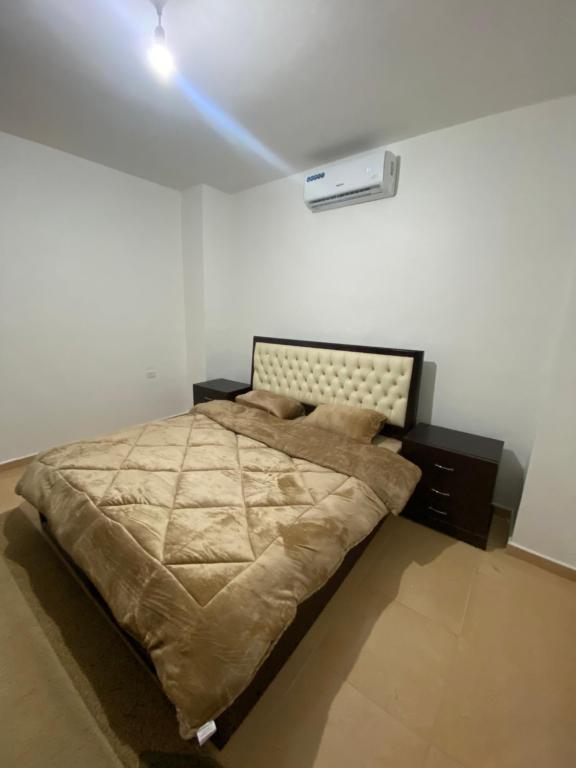 马达巴King mesha luxury apartment original的一间卧室配有一张天花板上灯的床