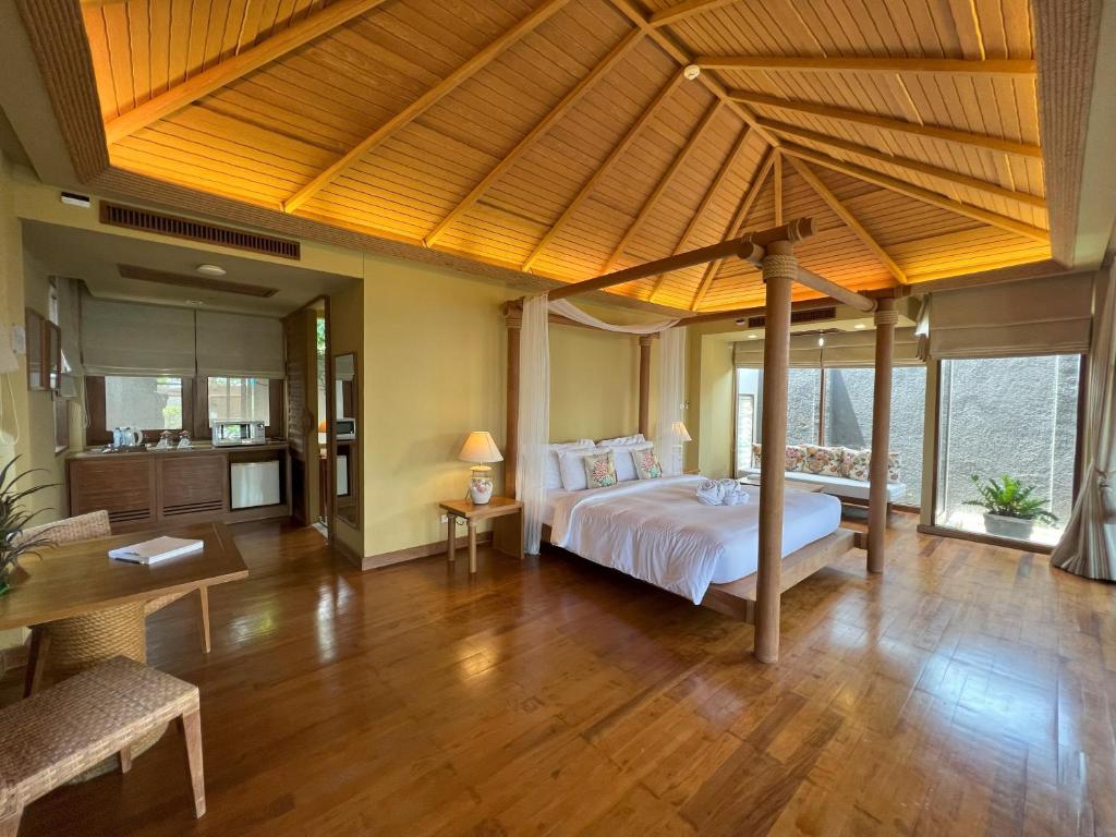 曾蒙海滩Deva Beach Resort Samui的一间卧室设有一张大床,铺有木地板