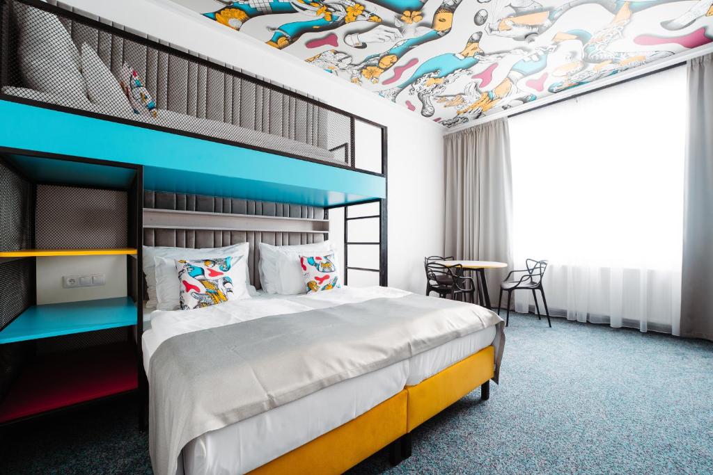 卡罗维发利Family Apartments by ASTORIA Hotel & Medical Spa的一间卧室设有一张色彩缤纷的天花板
