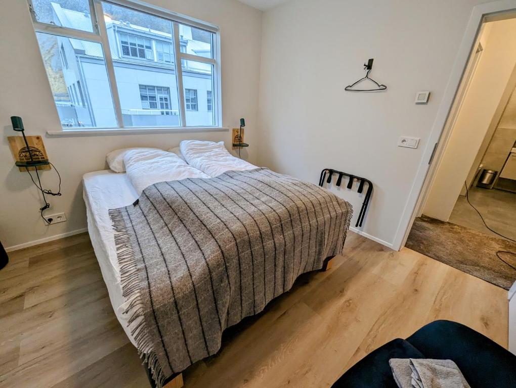 伊萨菲尔德The Ísafjörður Inn的一张位于带大窗户的房间内的床铺