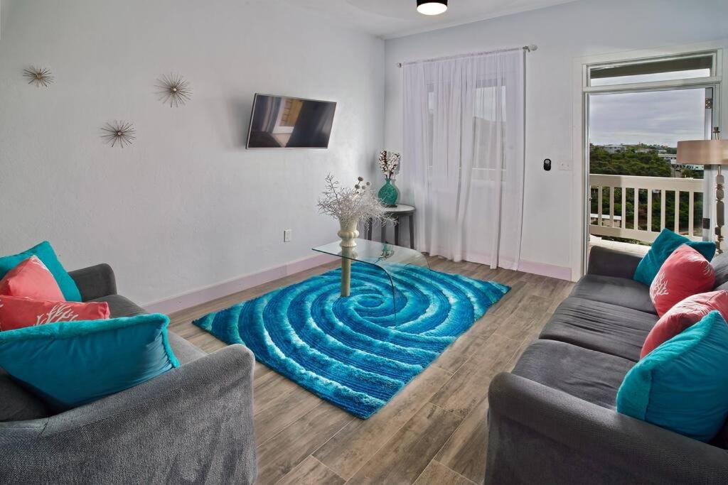 拿撒勒Scotland Villa 2的客厅的地板上铺有蓝色地毯。