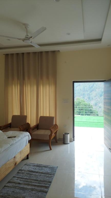 PhataHotel Anandam phata的一间卧室配有一张床、一张沙发和一个窗口