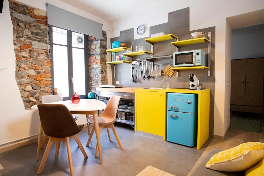 阿罗纳Baby Art Apartment的厨房配有黄色和蓝色的橱柜和桌子