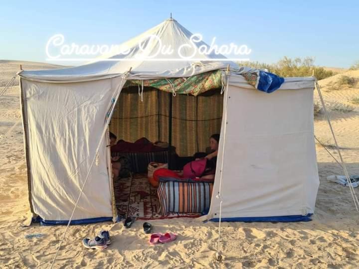 杜兹Private Camp25km-from DOUZ的坐在海滩帐篷里的男人