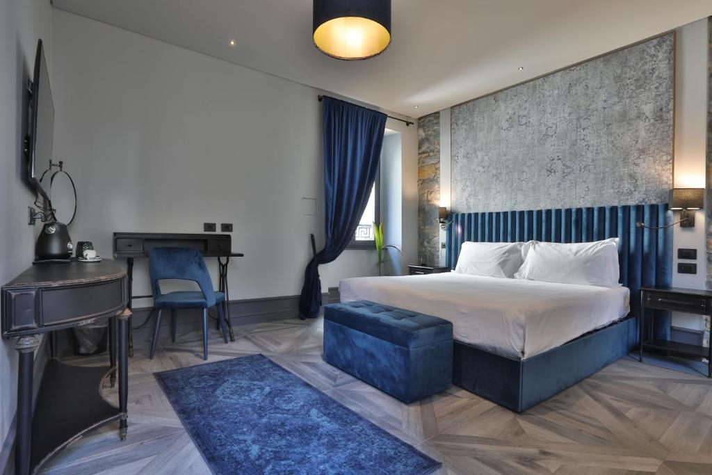 的里雅斯特FORVM bijoux ROOMS的配有一张床和一张书桌的酒店客房