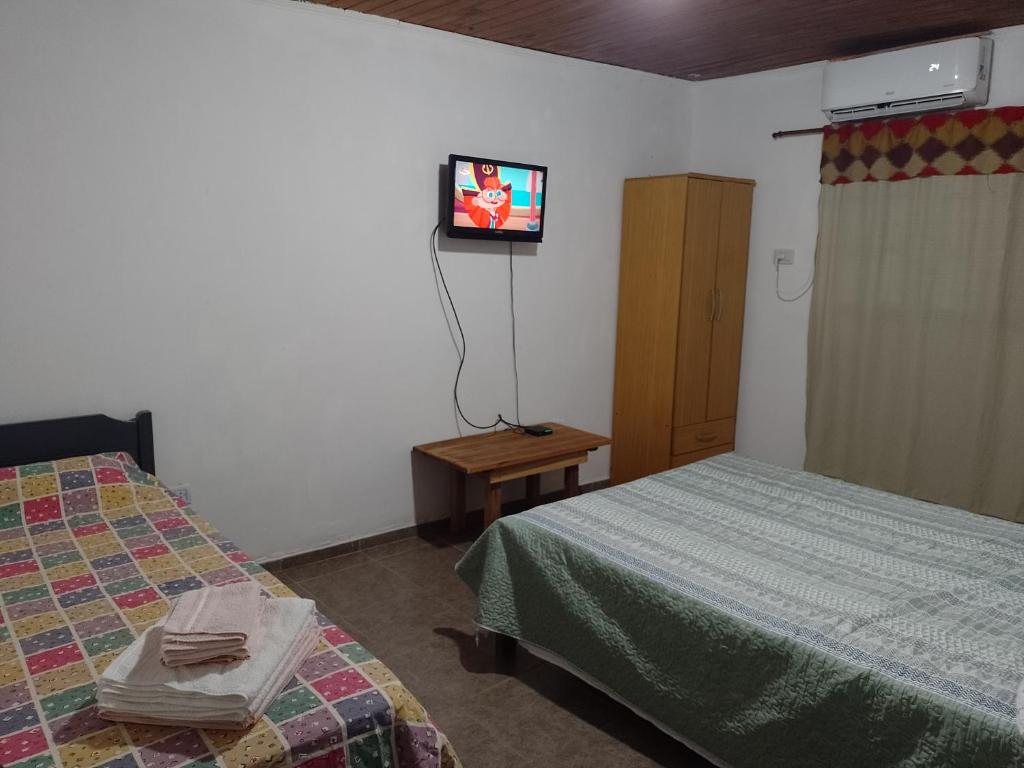 伊瓜苏港Departamento Florida的客房设有两张床和一台墙上的电视。