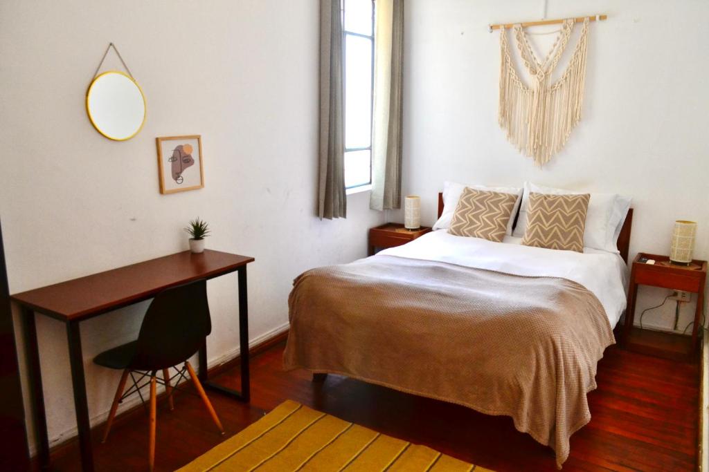 阿雷基帕Maison verte - Guest House的一间卧室配有一张床、一张桌子和一张桌子