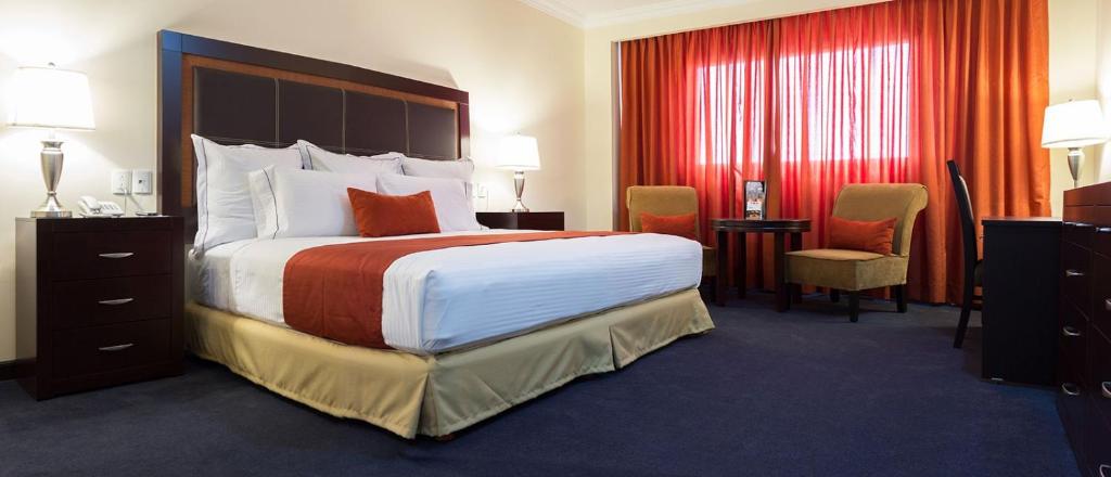 库利亚坎Hotel Two Select的酒店客房设有一张大床和一张书桌。