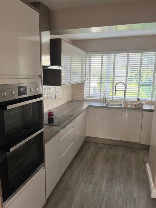 达灵顿Darlington Home Away From Home的厨房配有白色橱柜和炉灶烤箱。