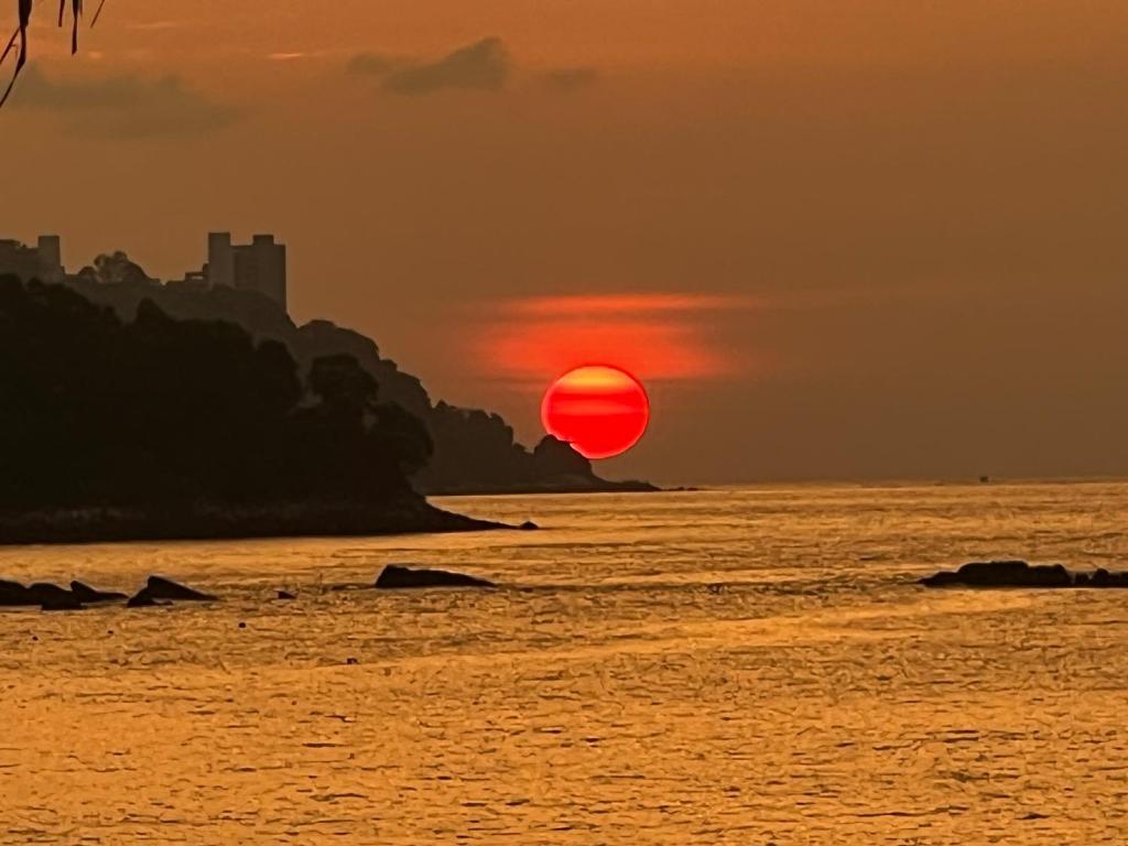 丹绒武雅The Beach Inn的日落时分飞过海洋的热气球