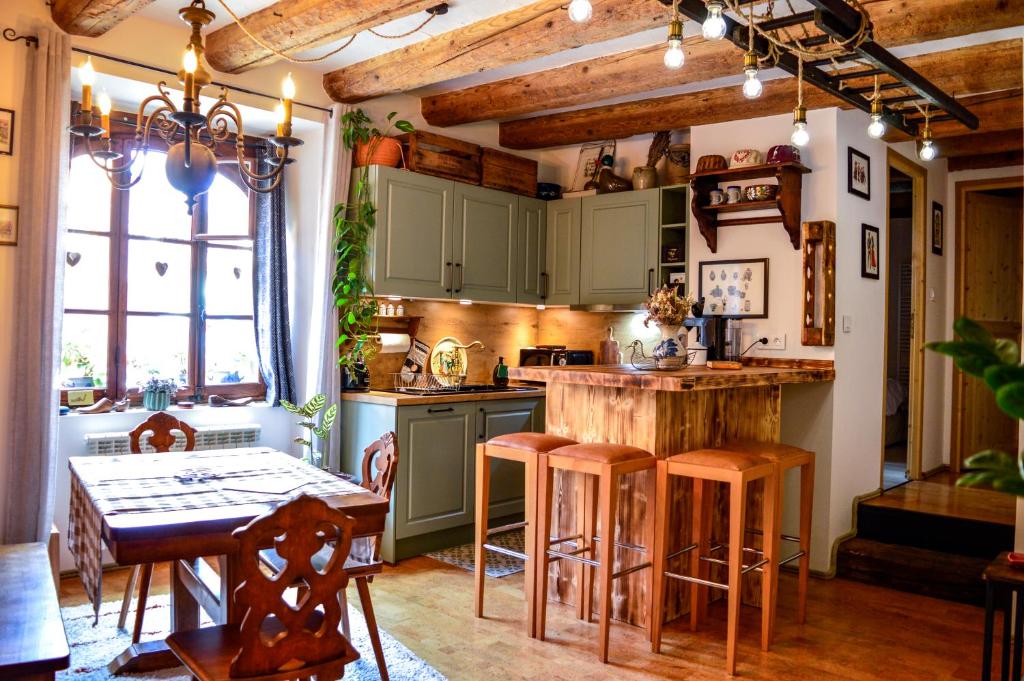 凯泽贝尔Chaud'Vin的厨房配有绿色橱柜和带凳子的桌子