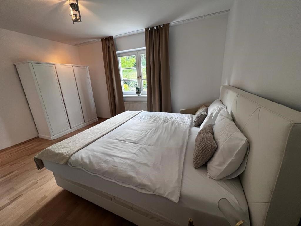 Green House bei Baden的卧室配有白色的床和窗户。
