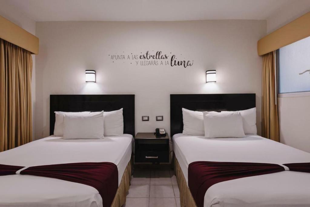 瓜伊马斯los rafeles 5的酒店客房设有两张床,墙上有标志