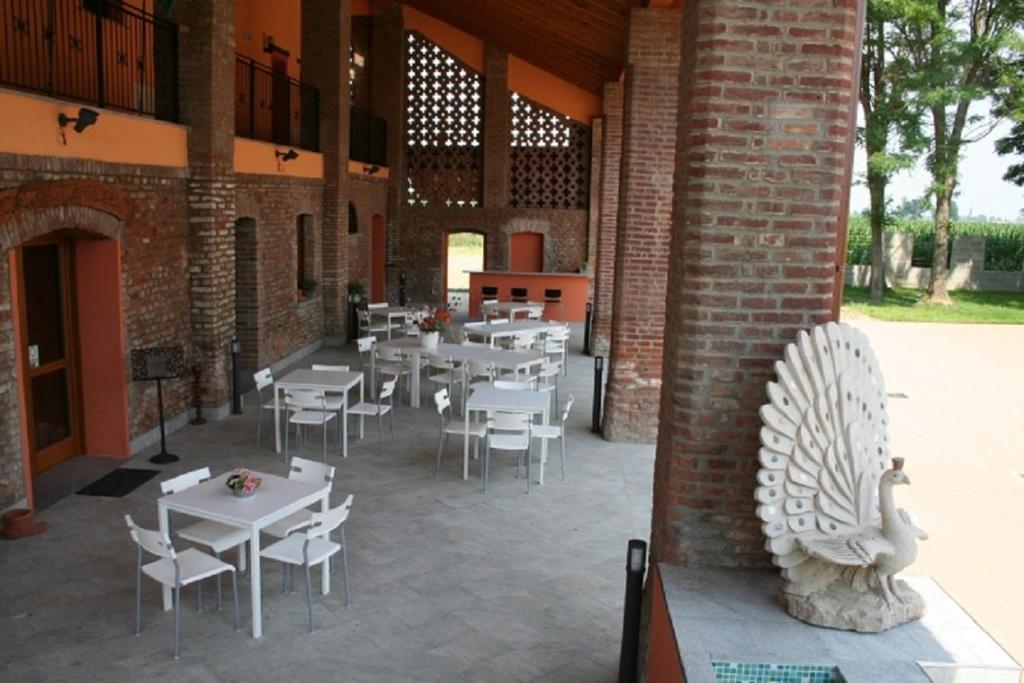 Borghetto LodigianoAntica Cascina B&B的庭院配有白色桌椅和鸟雕像