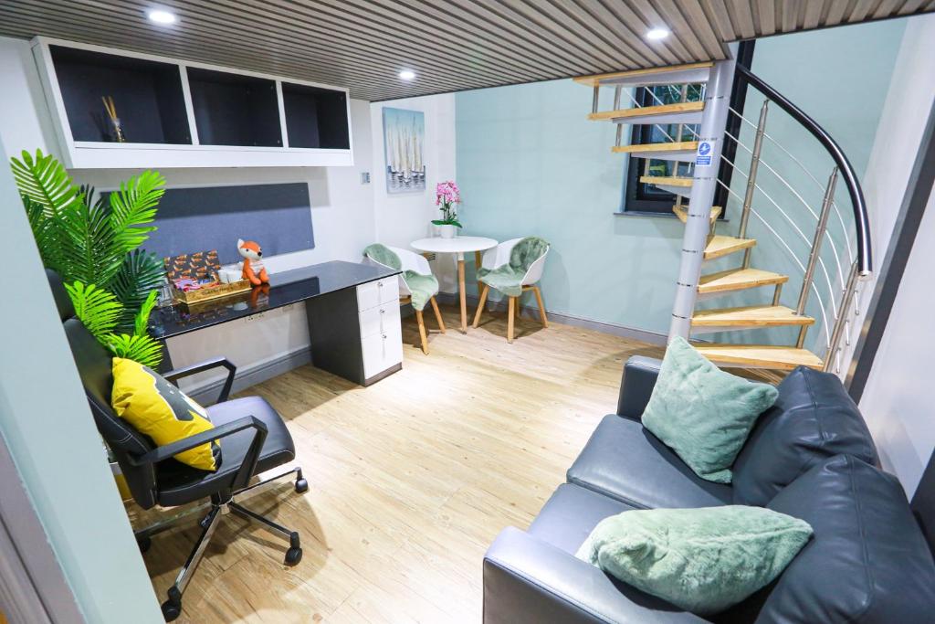 考文垂A101 Comfy Stylish Loft的客厅设有楼梯、沙发和桌子