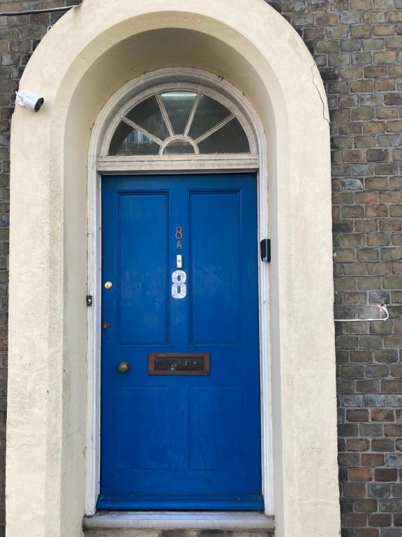 新港Town House 8-8A High Street的砖楼里的一扇蓝色门