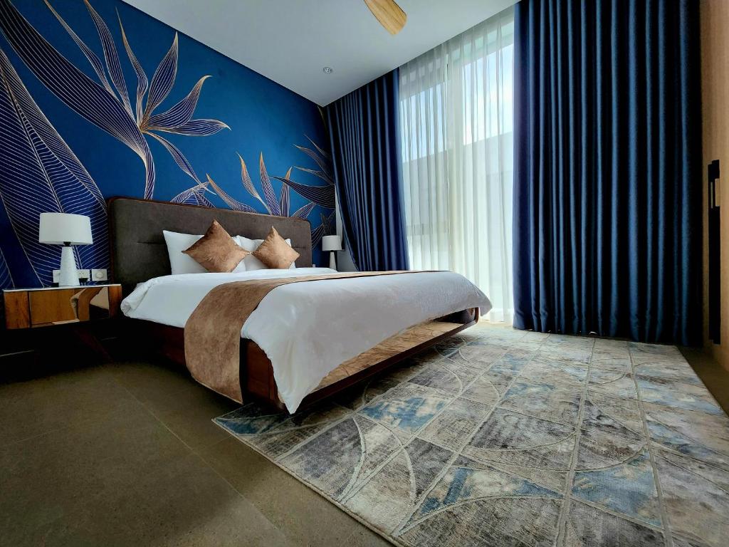 后川Villa 81 Sanctuary Hồ Tràm Resort, built on Jun 2023的一间卧室设有一张蓝色墙壁的大床