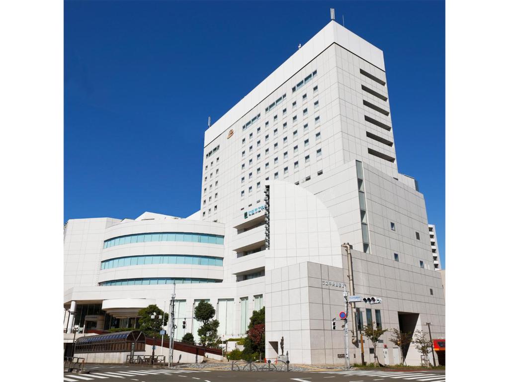 町田市Rembrandt Hotel Tokyo-Machida的一座白色的大建筑,有很多窗户