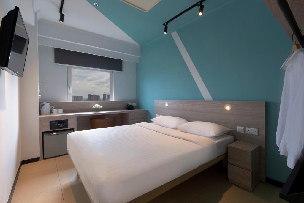 金边金边东横酒店的卧室配有白色的床和蓝色的墙壁