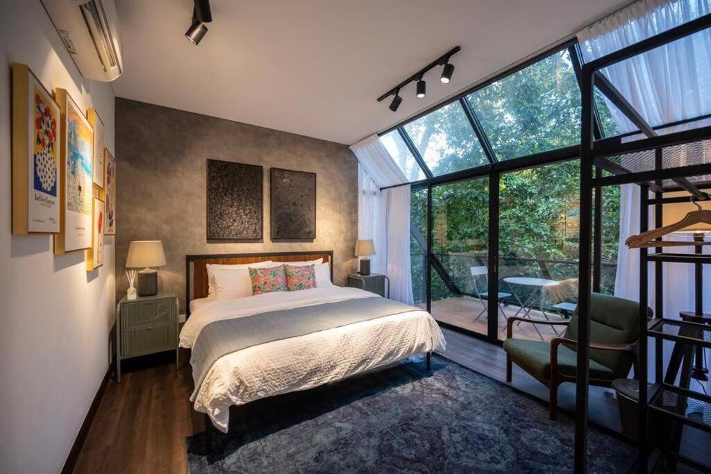 峇冬加里The Estate Hulu Rening - Private Retreat Cabin的一间卧室设有一张床和一个大窗户