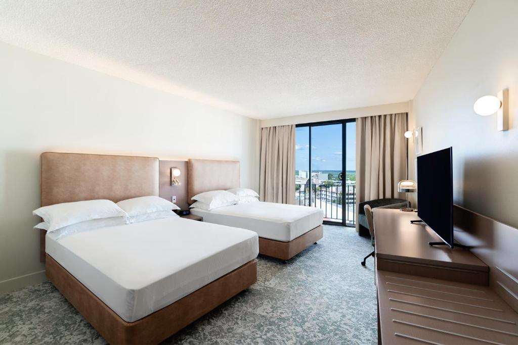 达尔文Hilton Garden Inn Darwin的酒店客房设有两张床和一台平面电视。