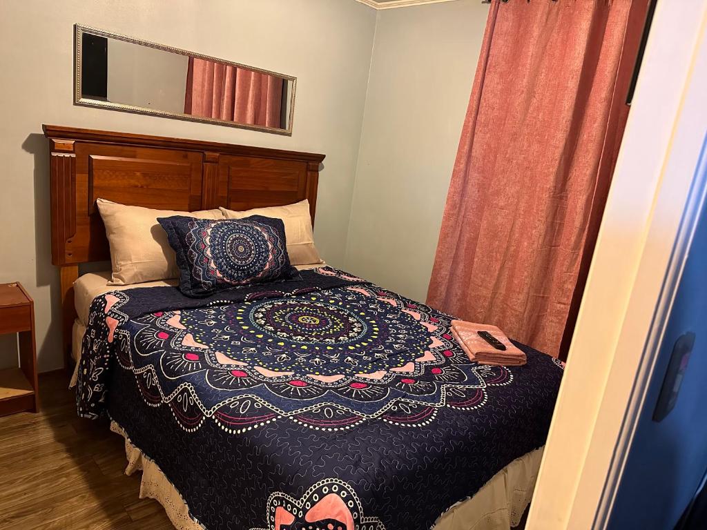 圣地亚哥Apartamentos Orquídea Suite的一间卧室配有一张带毯子和镜子的床