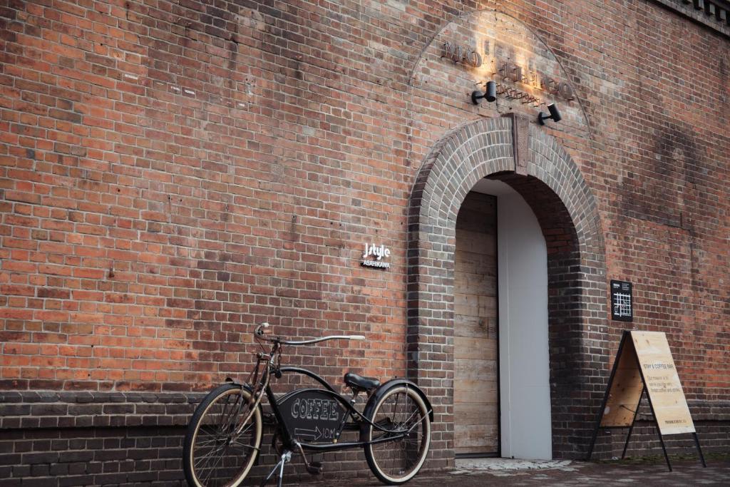 旭川Lampstand STAY Asahikawa的自行车停在砖墙旁边