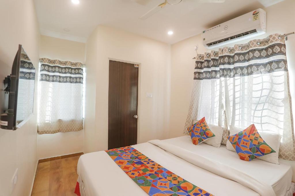 那格浦尔FabExpress Shivas Inn的一间卧室设有一张床、一台电视和窗户。