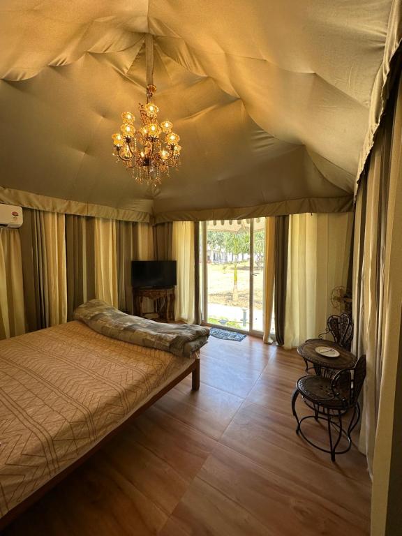 新德里Chitragarh Farm的一间卧室配有一张床和一个吊灯