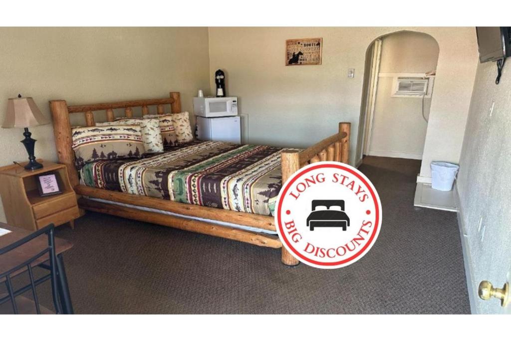 默多Love Hotels Murdo on Interstate 90的一间卧室,配有一张带标志的床